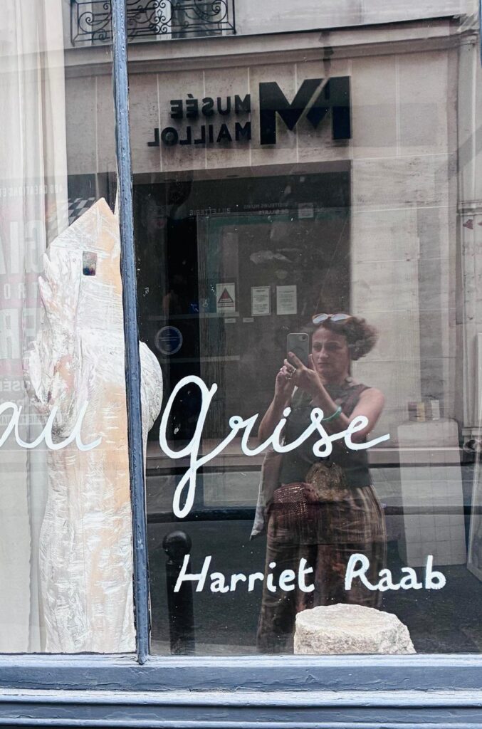 The L'Eau Grise gallery window, showing artist Harriet Raab's name, opposite the Musée Maillol.